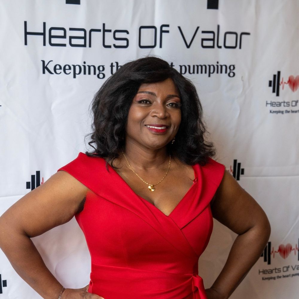 Kina Lucombe Founder Kina Lucombe at a Hearts of Valor Inc Gala event in a red evening gown.